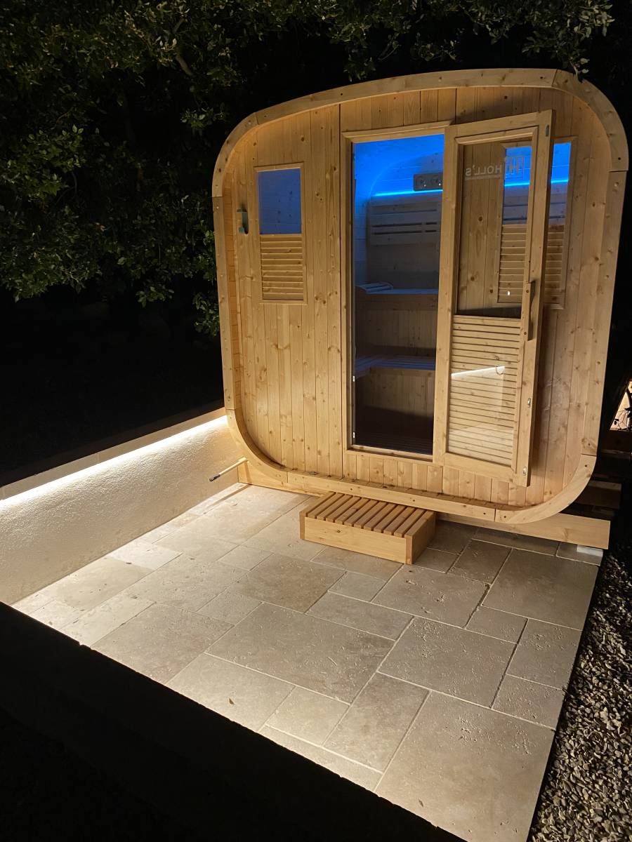 Installation d'un sauna Gaïa Nova extérieur traditionnel avec une douche solaire Jolly Go pour un havre de paix tout confort à La Bastide des Jourdans dans le 84